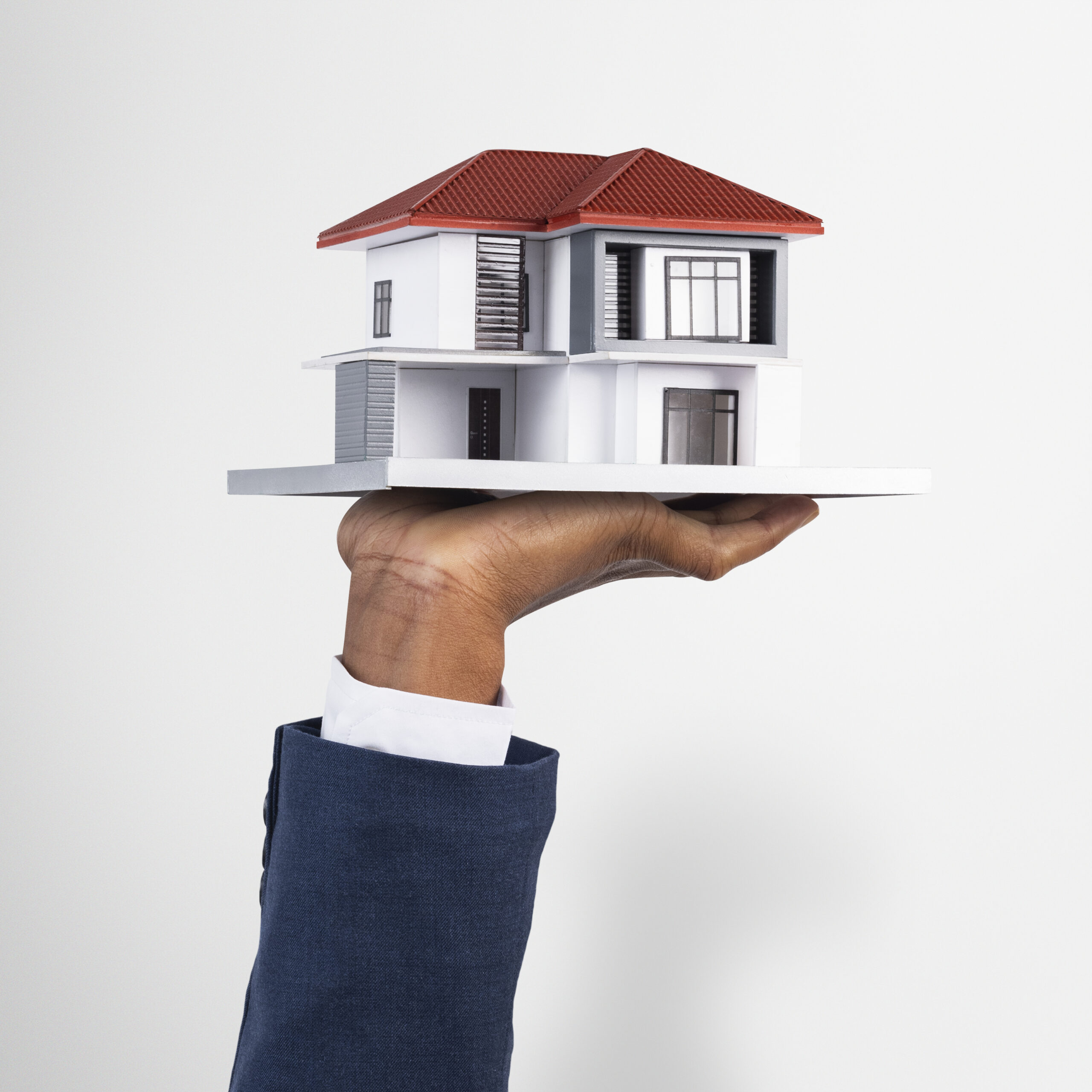 hand holding house real estate property model scaled